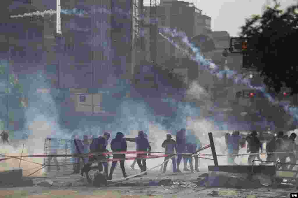 Un grupo de manifestantes se defienden de la policía durante una protesta