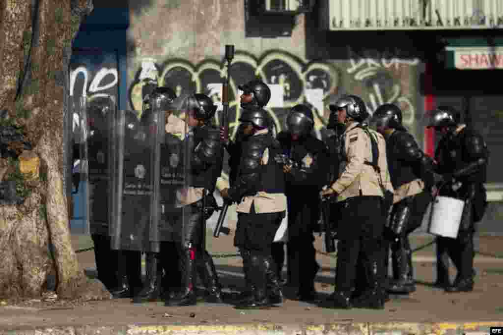 Un grupo de manifestantes se defienden de la policía durante una protesta