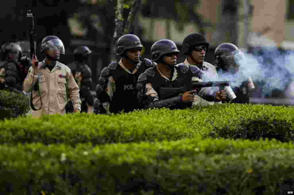 Un grupo de manifestantes se defienden de la policía durante una protesta