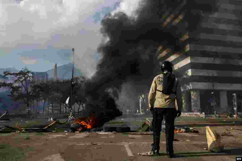 Un grupo de manifestantes se defienden de la policía durante una protesta